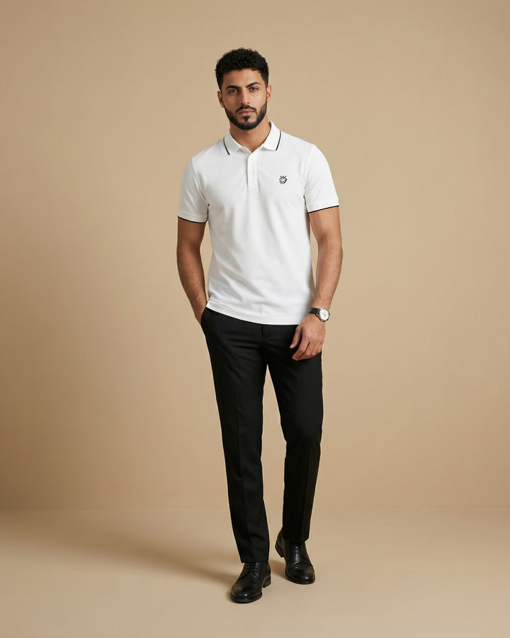 Man wearing a Cloud polo shirt and black pants on a beige background